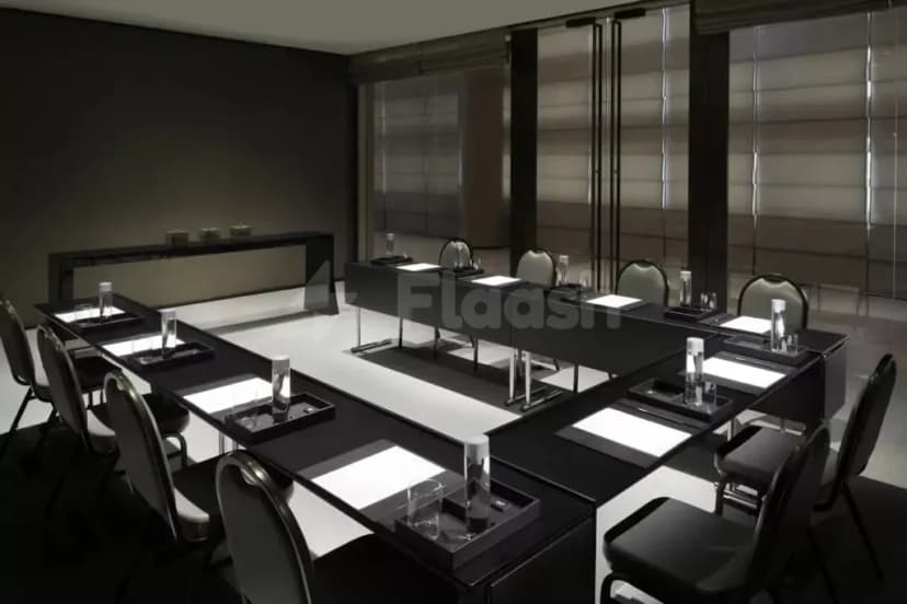 Boardroom at Armani Hotel Dubai featuring a black rectangular table, black chairs, white mats, and large glass windows
