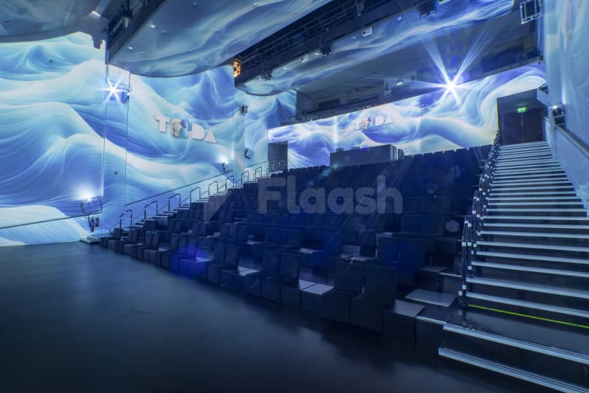 Tiered seating hall at TODA - Theatre Of Digital Art in Dubai with blue wave projection on curved walls