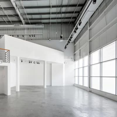 Meeting room at Alserkal Avenue in Dubai featuring an industrial ceiling with exposed ductwork and large windows allowing