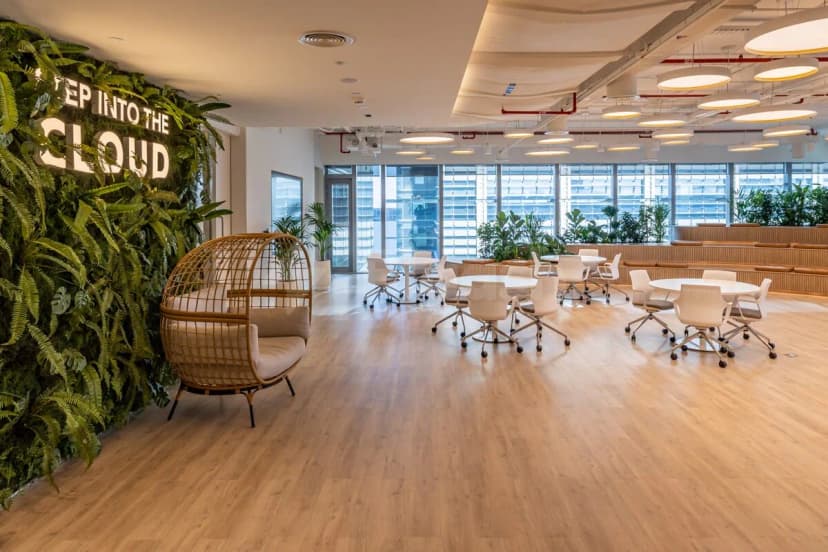Open meeting room at Cloud Spaces ADGM in Abu Dhabi with green living wall and illuminated sign