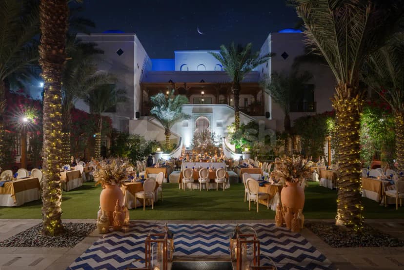 Rooftop terrace at Dubai Creek Golf & Yacht Club in Dubai with string-lit palm trees