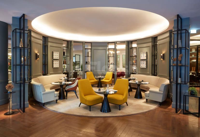 Restaurant with circular layout at La Brasserie Sur Le Boulevard in Dubai, featuring a beige rug and grey
