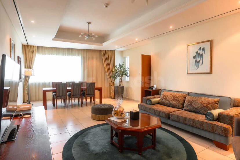 Living area at Tamani Hotel Marina in Dubai with a round rug and grey sofa