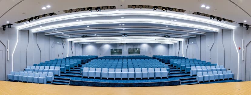 Meeting Room at SEE Institute in Dubai featuring tiered seating and a wooden stage floor with blue carpeting
