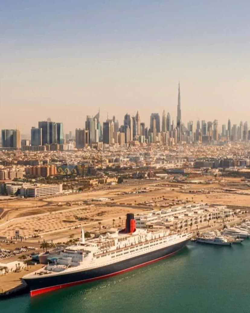 Theatre by QE2 facade featuring the historic QE2 cruise ship docked at Dubai Marina with Burj Khalifa