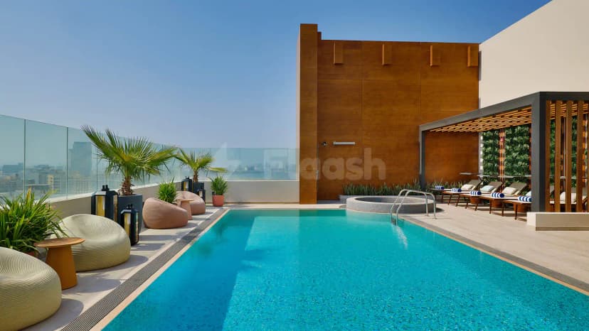Rooftop terrace at Courtyard by Marriott Culture Village, Dubai, featuring a rectangular swimming pool and circular hot tub
