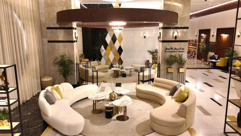 Entrance hall at Le Reve Hotel Taif featuring curved white and beige sofas, a round rug