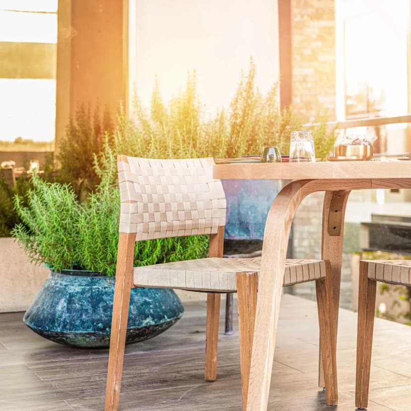Rooftop terrace at Suhail Arabic Restaurant Riyadh featuring a wooden table, woven strap chair, and large blue ceramic