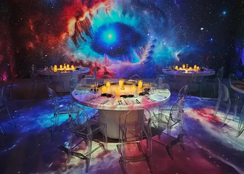 Ballroom at Kanvas Dubai featuring a cosmic mural wall and transparent acrylic chairs around round tables with white