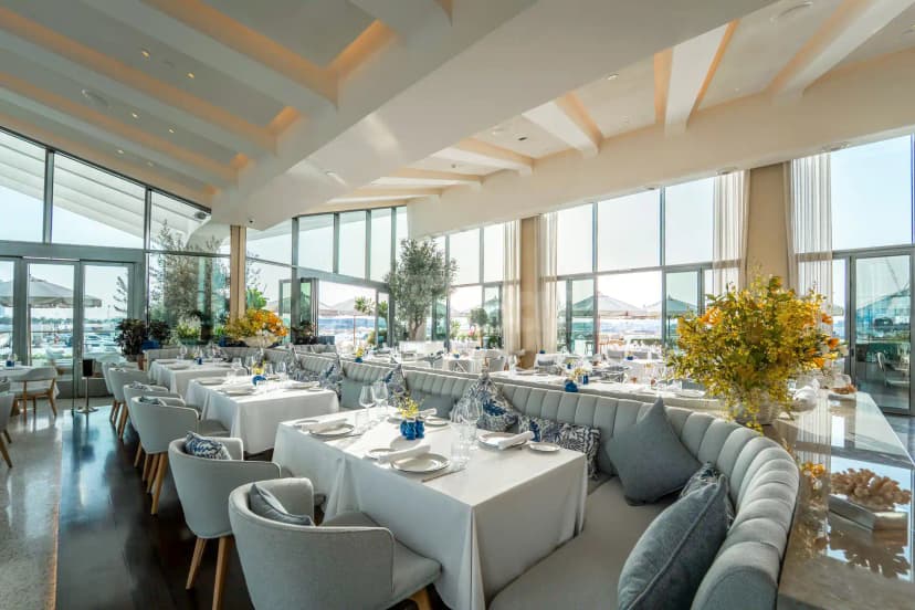 Dining area at L’Amo Bistro Del Mare in Dubai with large yellow floral arrangements