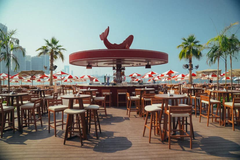 Rooftop terrace at February 30 in Dubai featuring a red whale sculpture and circular bar with wooden deck