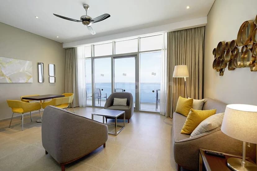 Meeting room at Hotel Riu Dubai featuring large glass doors opening to an ocean view and beige curtains