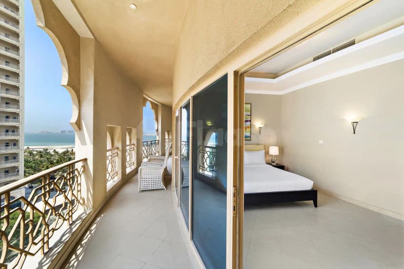 Curved balcony at Al Hamra Residence in Ras Al-Khaimah features ornate metal railing and arched openings overlooking