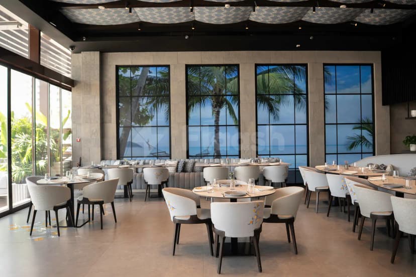 Round dining area at Bebabel The Palm Restaurant in Dubai with ocean-view windows