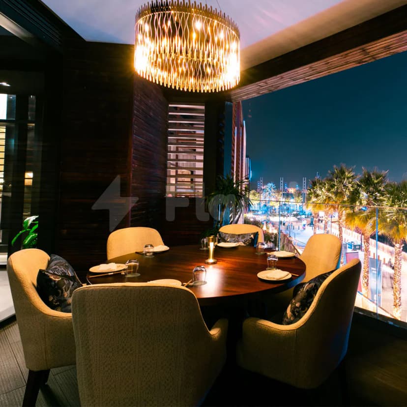 Rooftop dining space at Shi Restaurant Dubai Marina with brass pendant light and night city view