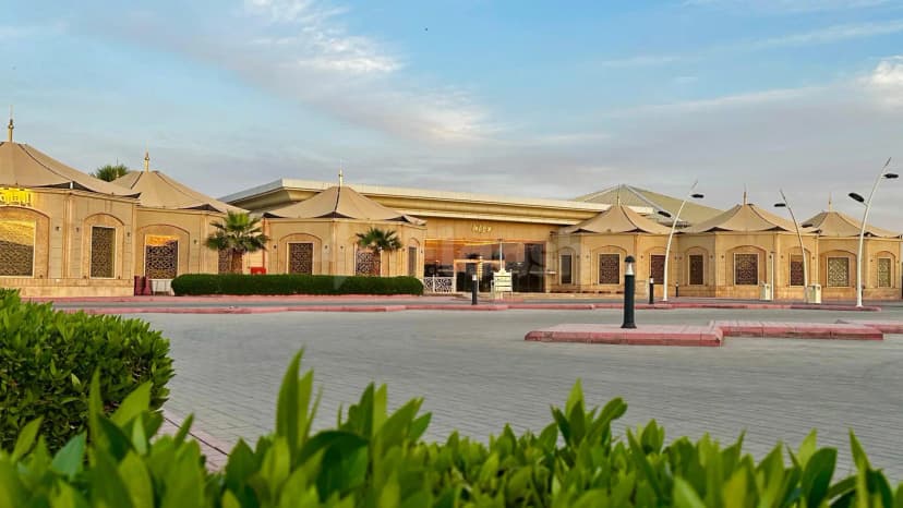 Hotel facade of H Laylati Event Venue in Madinah featuring beige canvas tent roofs and ornate metal window