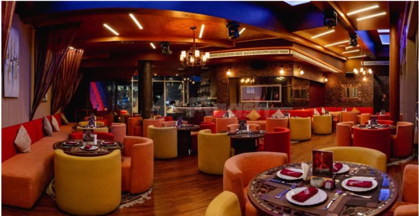Restaurant interior at Ornina Arabian Lounge in Abu Dhabi with circular ottoman-style seating and ambient lighting