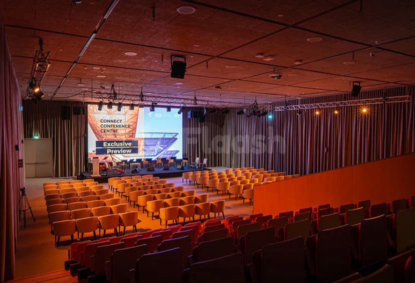 Ballroom at Connect Conference Centre, Expo City Dubai, featuring tiered seating, a large projection screen, and stage lighting