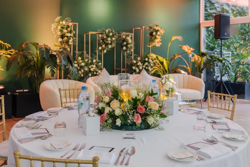 Round table set for a reception at The Farm Restaurant Al Barari in Dubai, featuring a floral centerpiece