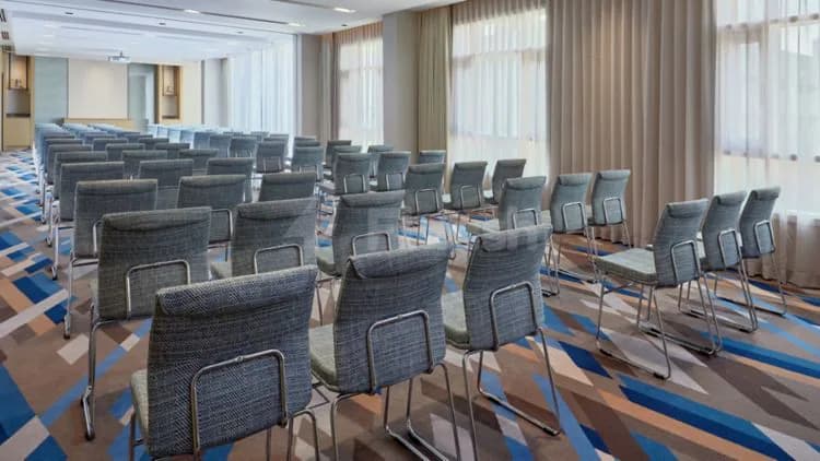 Meeting room at Courtyard Jubail in Al Jubail with rows of chairs and patterned carpet