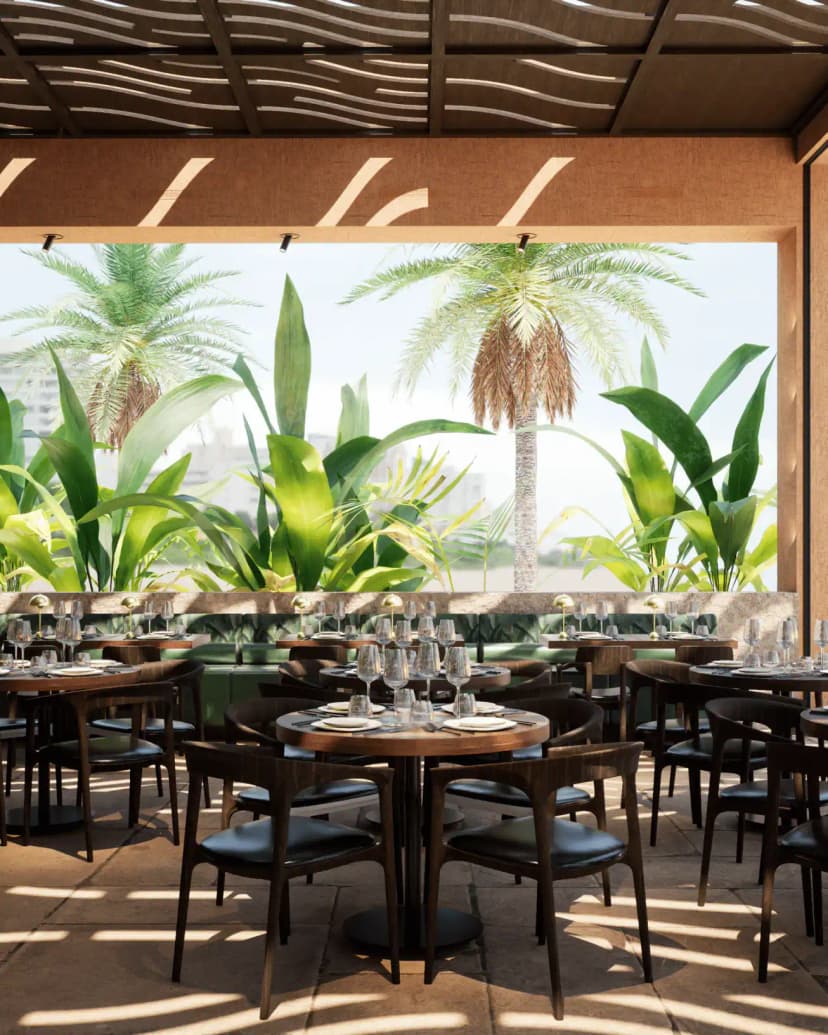 Rooftop terrace at Kaimana Restaurant and Beach in Dubai with round wooden tables, black leather chairs
