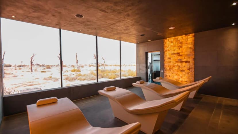 Modern lounge area at Al Faya Retreat in Sharjah featuring beige leather recliners and large floor-to-ceiling windows