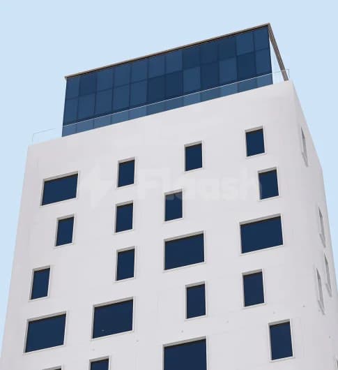 Hotel facade of Form Hotel Dubai featuring white exterior walls, dark blue rectangular windows, and a rooftop glass