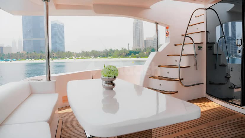 Terrace on Xclusive 35 Yacht Dubai featuring a white table with green hydrangeas, wooden deck, and city skyline