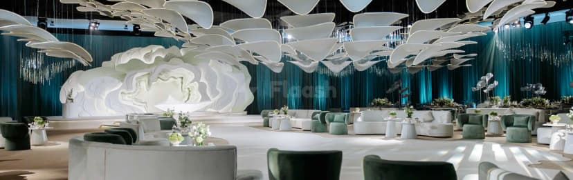 Ballroom at Al Jawaher Reception and Convention Centre in Sharjah featuring a white sculptural stage backdrop and suspended