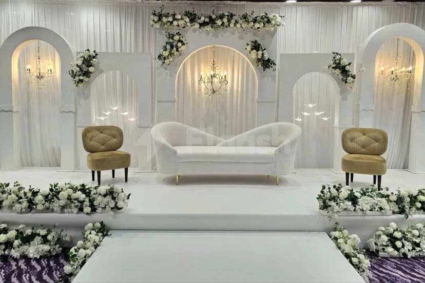 Ballroom at Time Rako Hotel Qatar in Doha with white arched backdrop and floral garlands