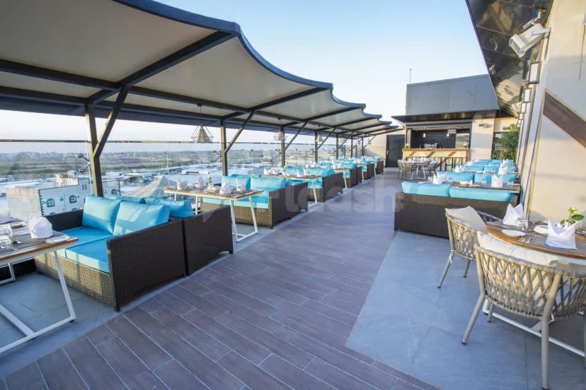 Rooftop terrace at Velar Inn Hotel Taif featuring a canopy roof and city view with low-rise buildings