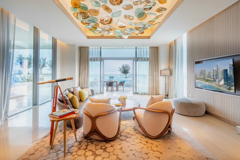 Modern lounge seating area at Five Luxe JBR Dubai with large windows and a distinctive glass pendant light