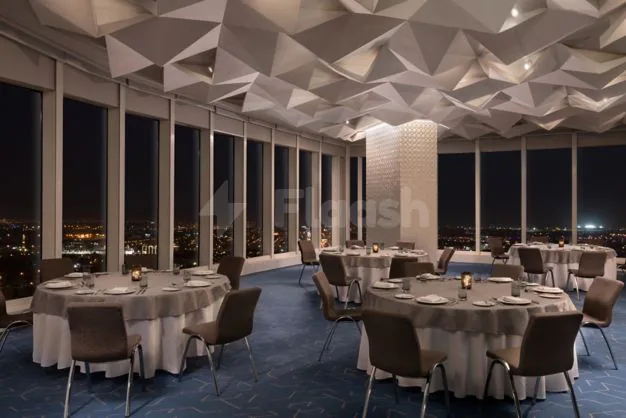 Ballroom at Le Meridien Riyadh featuring geometric ceiling panels and floor-to-ceiling windows overlooking the city at night