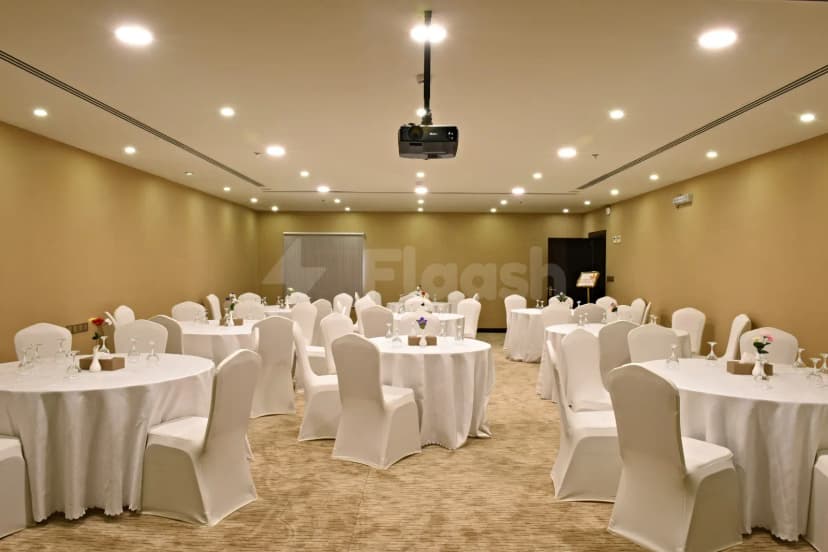 Meeting room at Garden Plaza Al Hafouf in Al Hofuf with round tables, white linens, and a ceiling-mounted