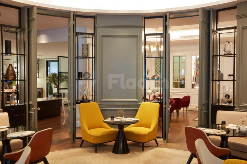 Restaurant at La Brasserie Sur Le Boulevard in Dubai with grey paneled walls and open double doors