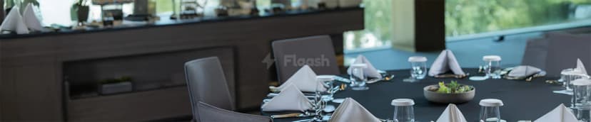 Restaurant at Dubai Exhibition Centre in Dubai featuring a black tablecloth, grey upholstered chairs, and white folded napkins