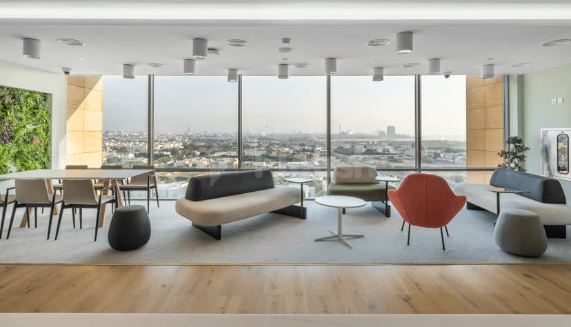 Meeting room at Gravita Coworking Space Jeddah featuring floor-to-ceiling windows with city views and a green living