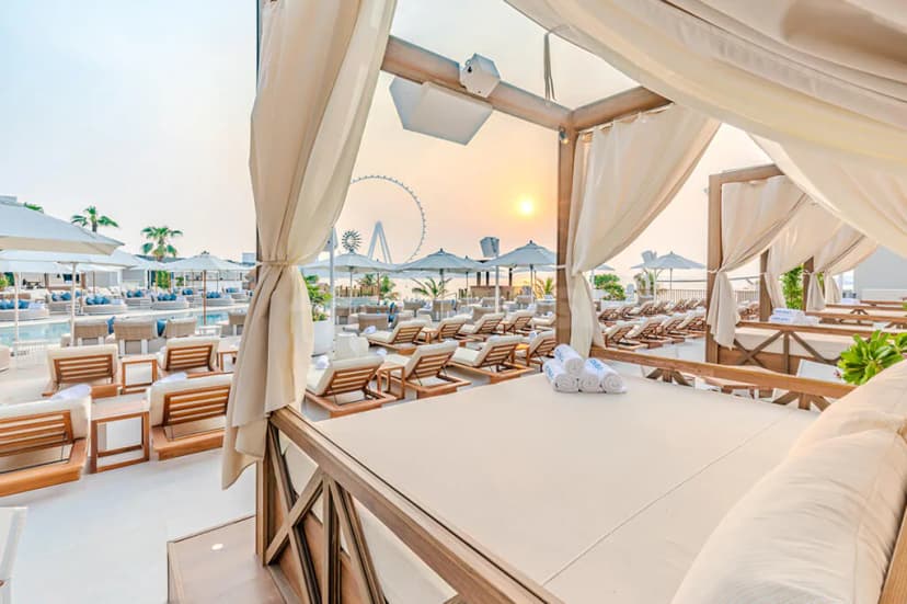Rooftop terrace at Cove Beach Dubai with cream canopy and Ferris wheel view