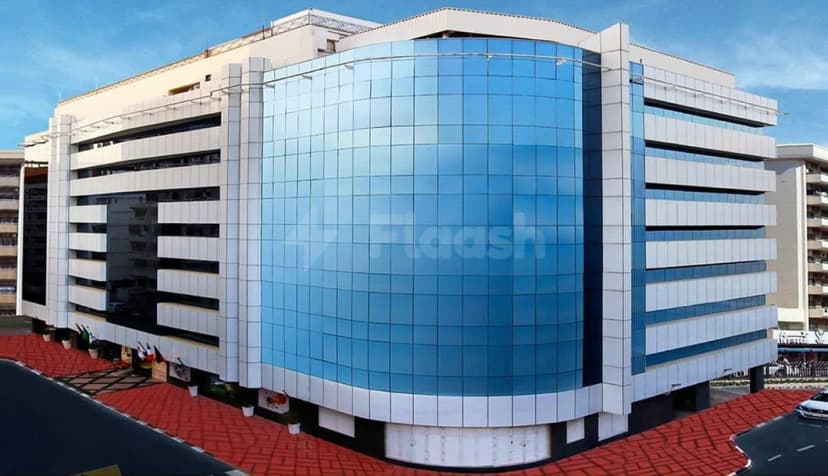 Hotel facade of Excelsior Hotel Downtown in Dubai featuring a curved blue glass wall and white stone cladding
