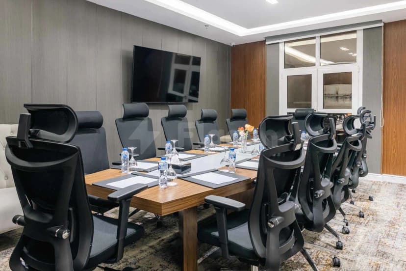 Boardroom at Swiss International Taif in Taif featuring a long wooden table with black ergonomic chairs