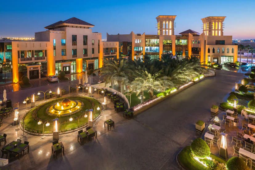 Rooftop terrace at Al Mashreq Boutique Hotel in Riyadh featuring a circular garden with illuminated fountain and palm
