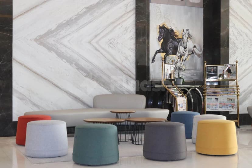 Entrance hall at TIME Onyx Hotel Apartments Dubai featuring a marble wall and large horse painting above modern