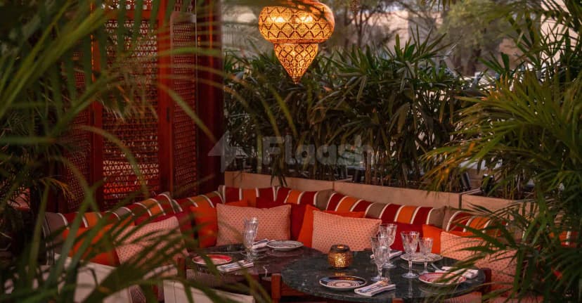 Outdoor dining area at Ninive Bab Al Shams Restaurant Dubai featuring a round marble table, ornate pendant light