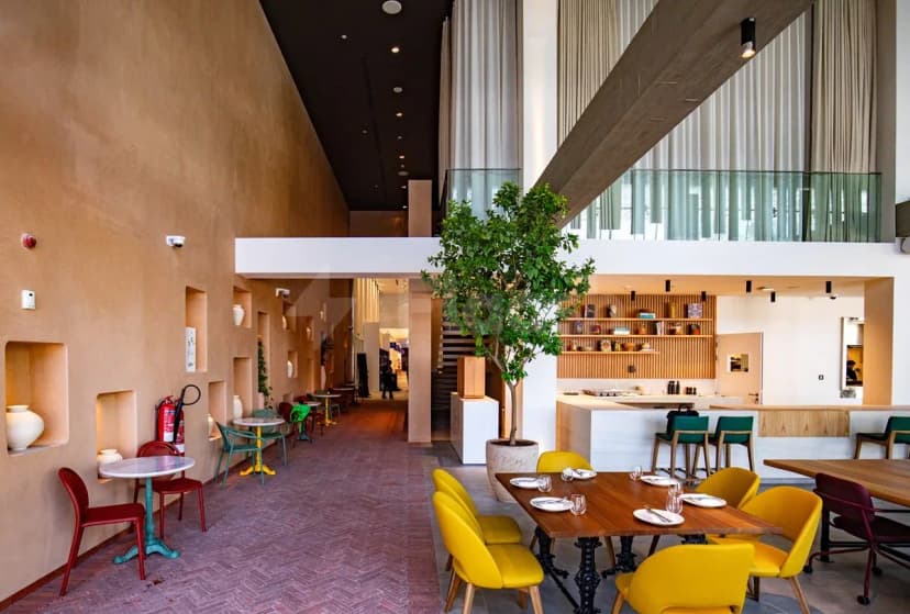 Taparelle Restaurant in Abu Dhabi features a modern dining space with an indoor tree and terracotta walls