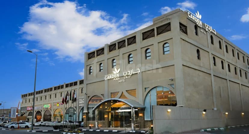 Hotel facade of Garden Plaza Al Hafouf in Al Hofuf featuring an arched glass entrance with metal canopy
