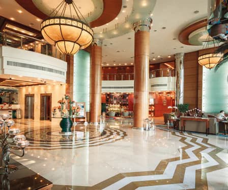 Spacious entrance hall at Swissotel Al Murooj Dubai with zigzag-patterned marble floor