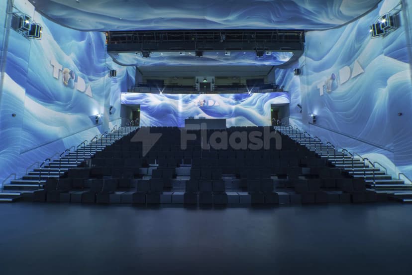 Tiered seating hall at TODA - Theatre Of Digital Art in Dubai with blue wave projection on walls