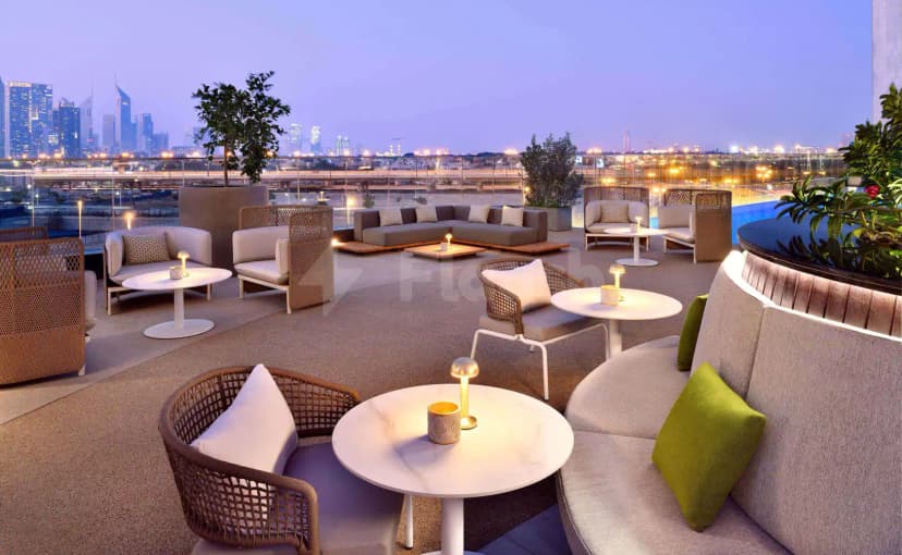 Rooftop terrace at Open Sesame Dubai featuring modern seating, ambient lighting, and a twilight city skyline view