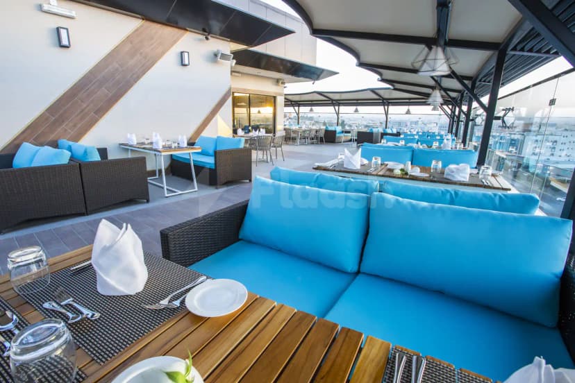 Rooftop terrace at Velar Inn Hotel Taif featuring modern lounge seating and a glass railing with city view