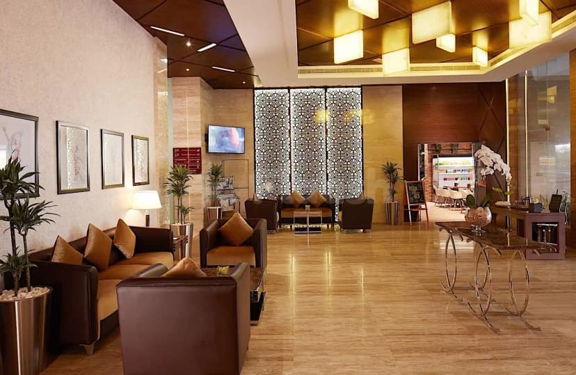 Entrance hall at Treppan Hotel & Suites in Dubai featuring a decorative geometric screen wall and polished beige tile